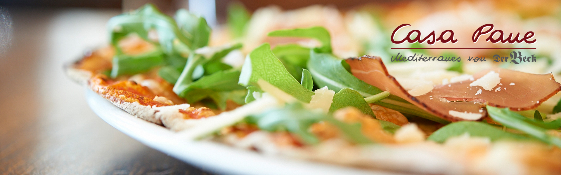 Pizza mit Schinken und Rucola und das Logo von Casa Pane